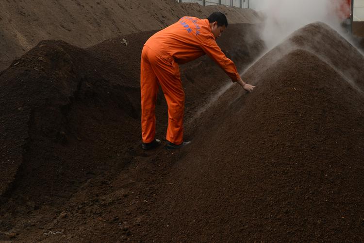 在湖北恩施一家生物有机肥厂,一名工人在观察肥料发酵程度.